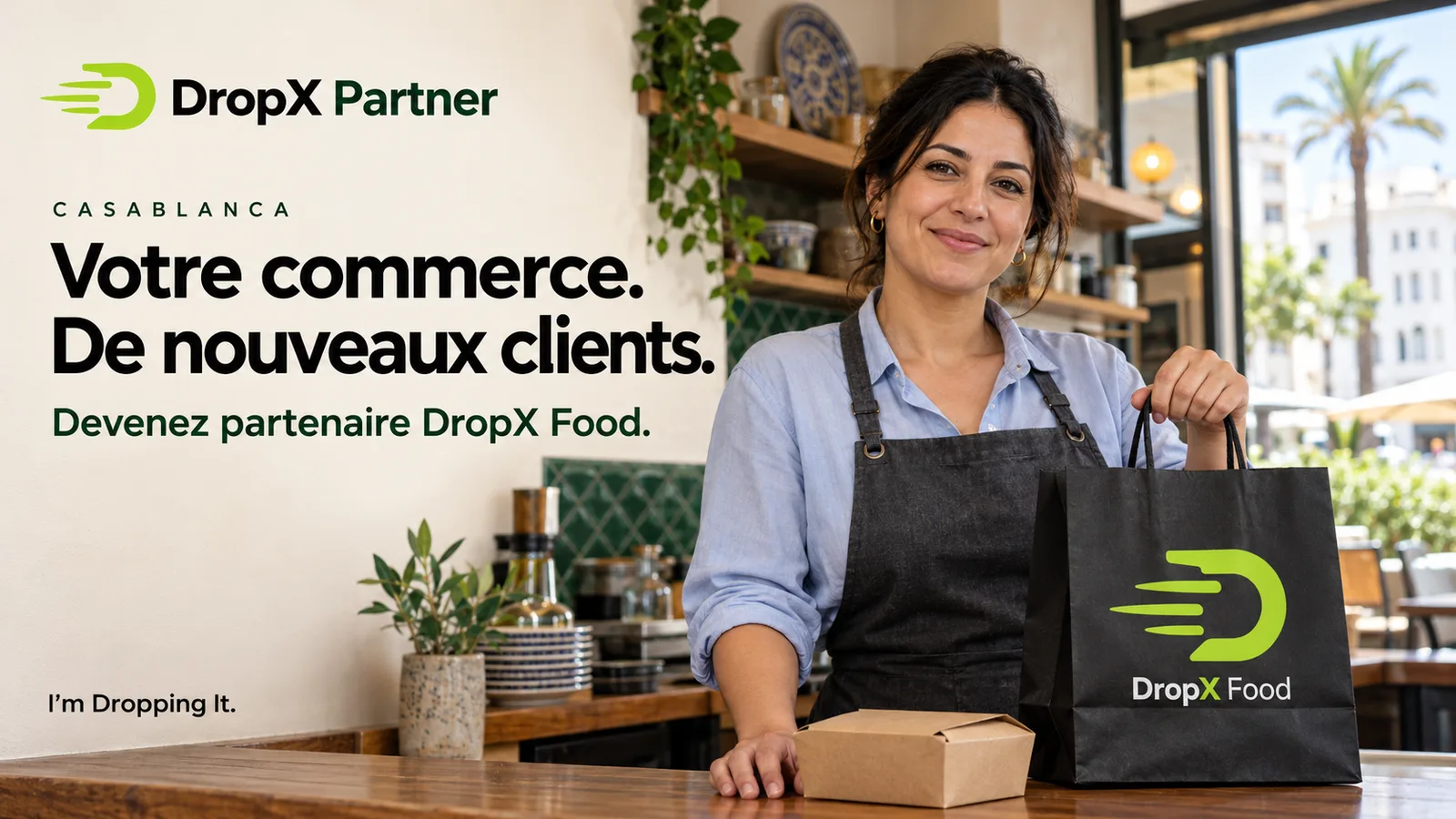 Restauratrice derrière son comptoir avec un sac noir DropX Food, pour la campagne de recherche de commerces partenaires à Casablanca.